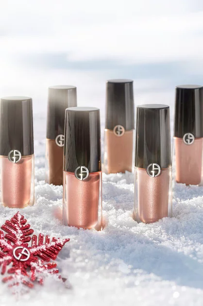 Armani beauty Eye Tint liquid eyeshadows on snow with a red holiday ornament.