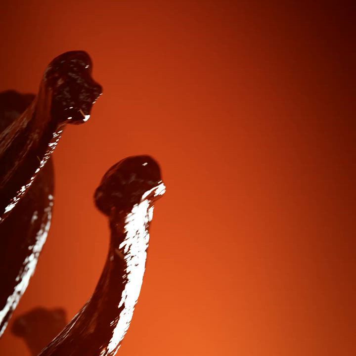 A perfume bottle for "EMPORIO ARMANI STRONGER WITH YOU SPICES" scent, featuring a warm, amber-toned bottle with a metallic cap. It is artfully arranged with vanilla pods and saffron threads against a vibrant red-orange background, highlighting the aromatic spices.