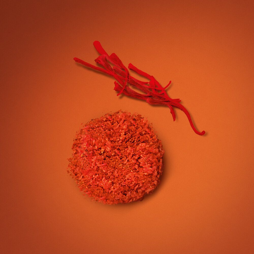 Fragrance notes of saffron and a textured spice accord for EMPORIO ARMANI STRONGER WITH YOU SPICES, showcased on an orange background to emphasize its vibrant, spicy signature.