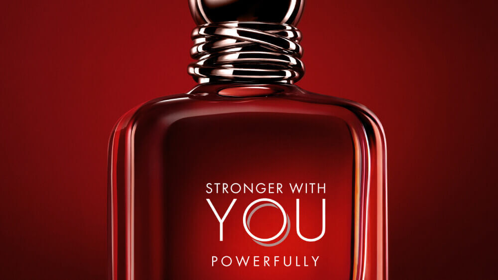 Emporio Armani Stronger With You Powerfully bottle on a bold red background.