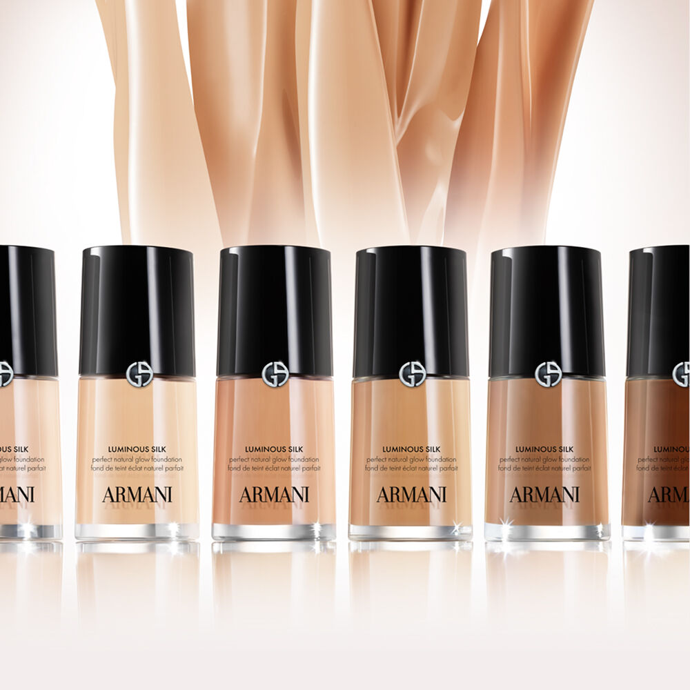 A close-up of Sydney Sweeney wearing Armani Luminous Silk foundation, with the product bottle shown in the bottom right corner.