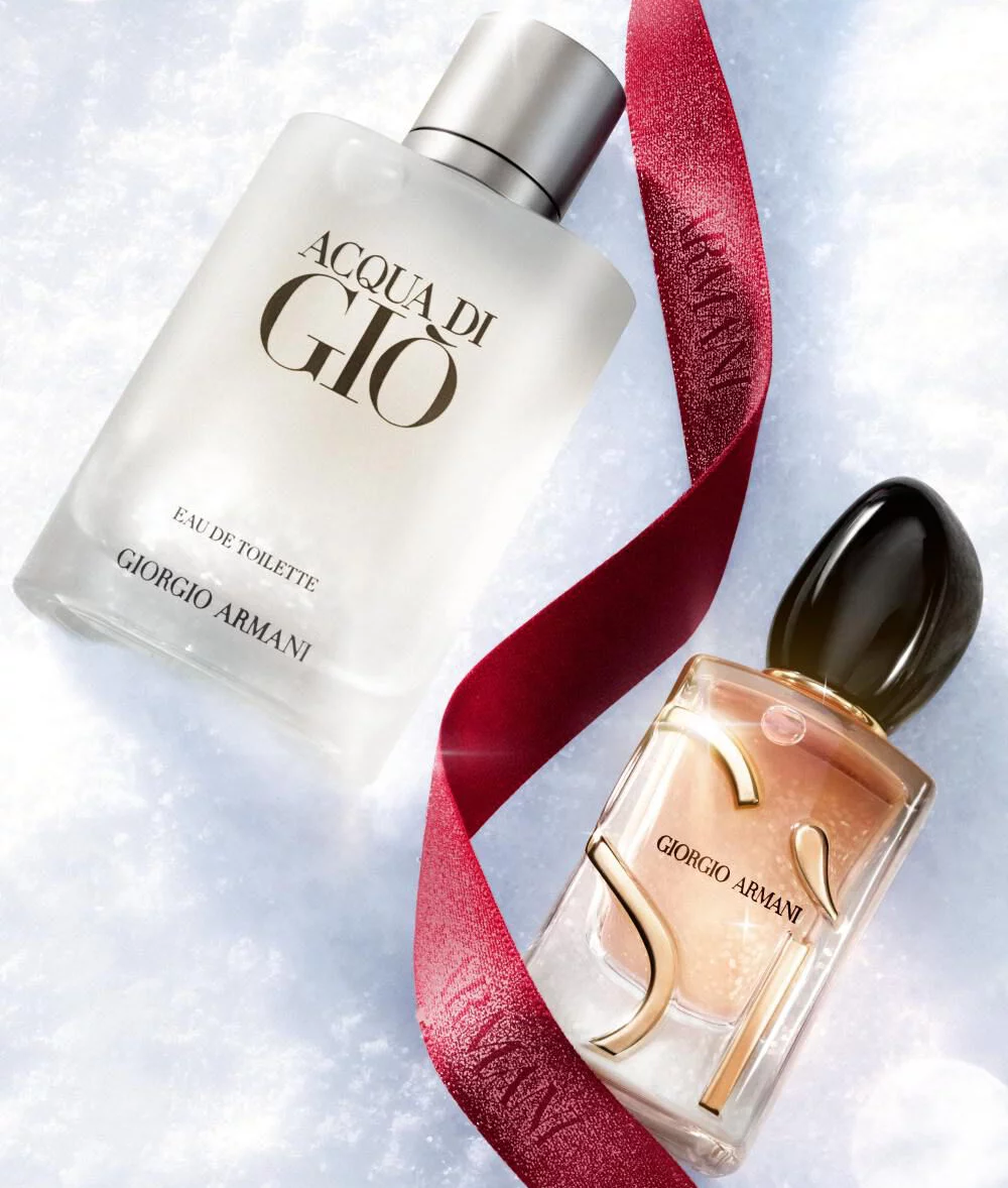 Giorgio Armani fragrances on snow with a red ribbon for the holiday season.