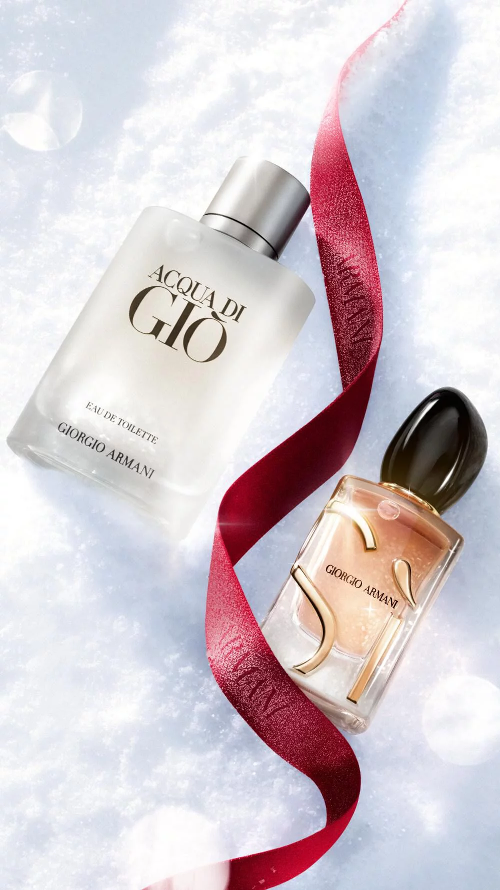 Les parfums Giorgio Armani sur la neige avec un ruban rouge pour le temps des fetes.