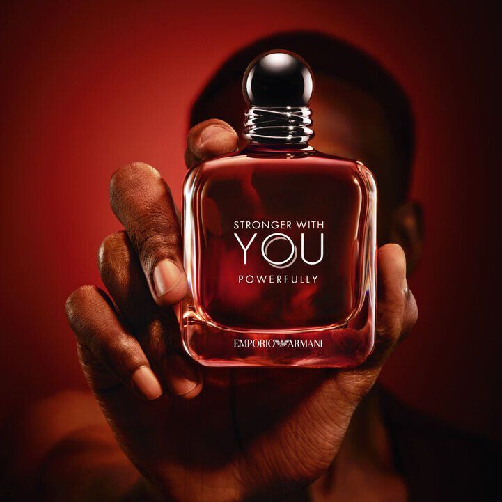 Emporio Armani Stronger With You Powerfully bottle on a bold red background.
