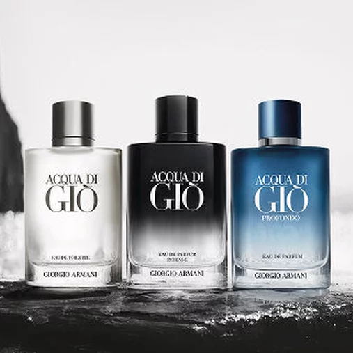 Three Armani fragrance bottles on a wet surface, emphasizing the brand’s elegant and aquatic identity.