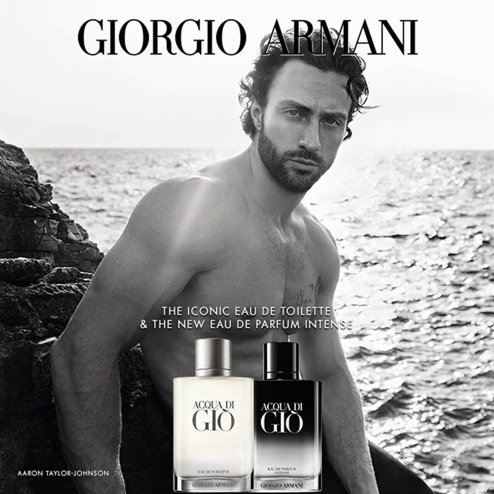 Giorgio Armani Acqua Di Gio Eau de Toilette and Eau de Parfum Intense bottles by the sea. Aaron Taylor-Johnson appears in the background.