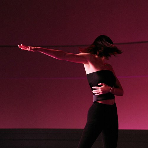 Kendall Jenner dancing under soft ruby light, captured in an inspiring moment of movement and self-expression for ARMANI POWER OF YOU.