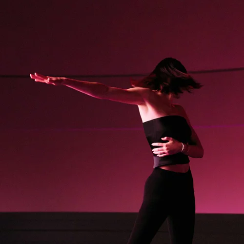 Kendall Jenner dancing under soft ruby light, captured in an inspiring moment of movement and self-expression for ARMANI POWER OF YOU.