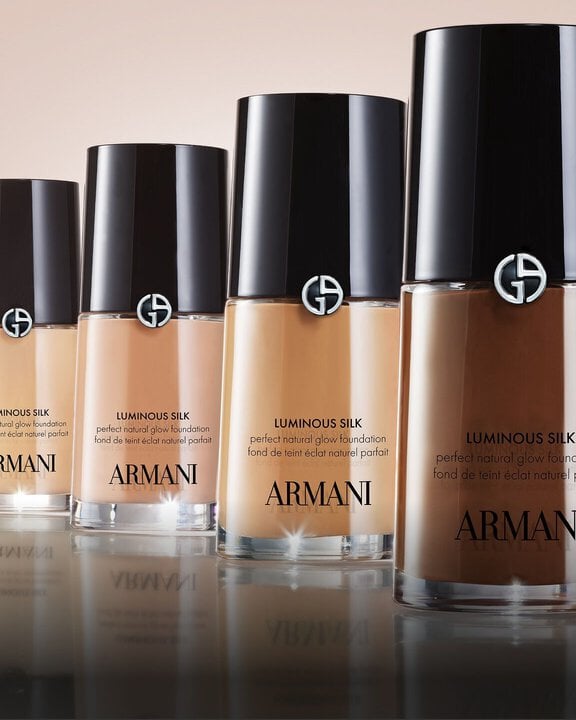 A row of multiple Armani beauty Luminous Silk Foundation bottles in varying shades, from light to dark, demonstrating the reimagined and expanded 44-shade range designed for an even better color match.