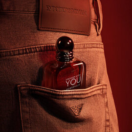 Armani fragrance bottle tucked stylishly into a denim pocket.