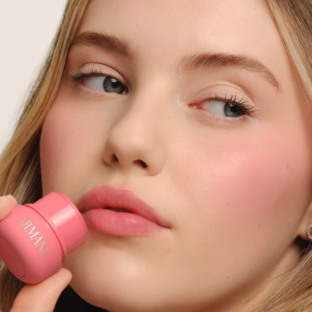 Model applying ARMANI Beauty Dolci Blush pink cheek tint to the lips