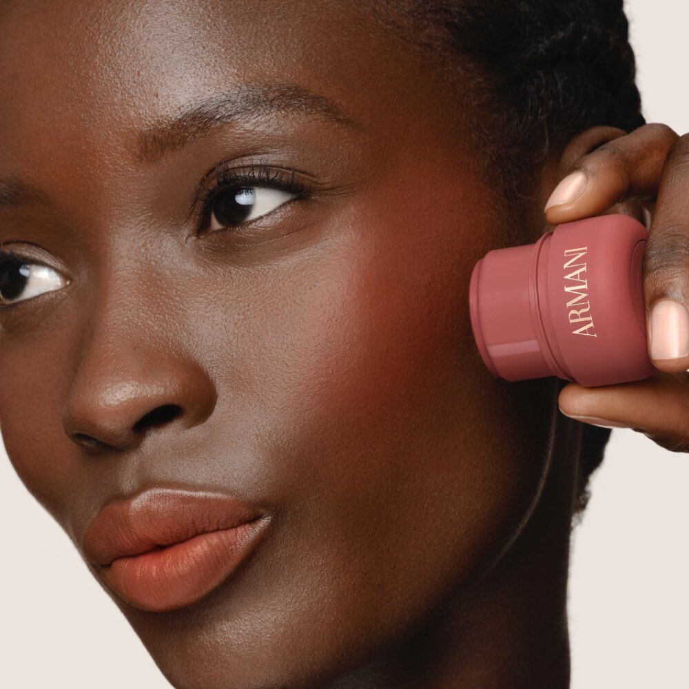 Model applying ARMANI Beauty Dolci Blush pink cheek tint to the lips